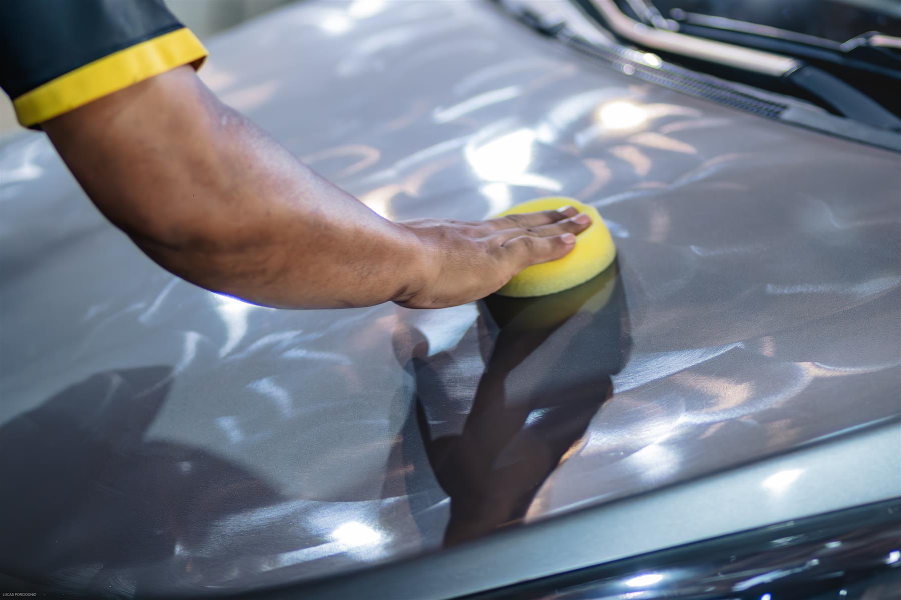 Aplicação manual de produto no capô do carro